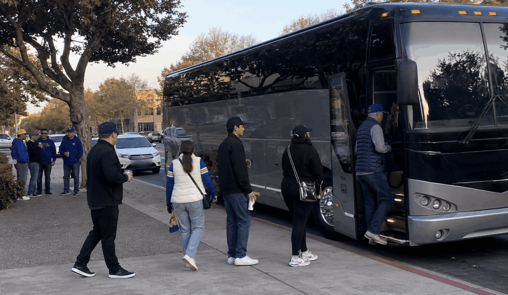group boarding a charter bus in alameda before leaving for a chase center game or concert in san francisco