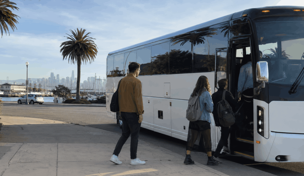 group boarding a charter bus in alameda for a trip to outside lands at golden gate park