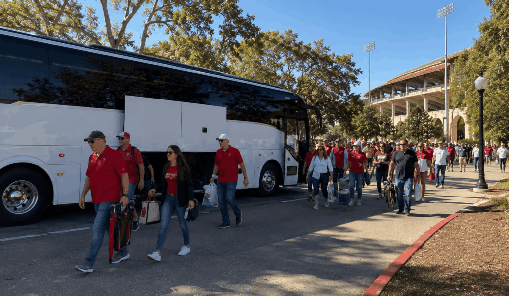 college football tailgate group gathered beside a charter bus before a stanford or cal football game