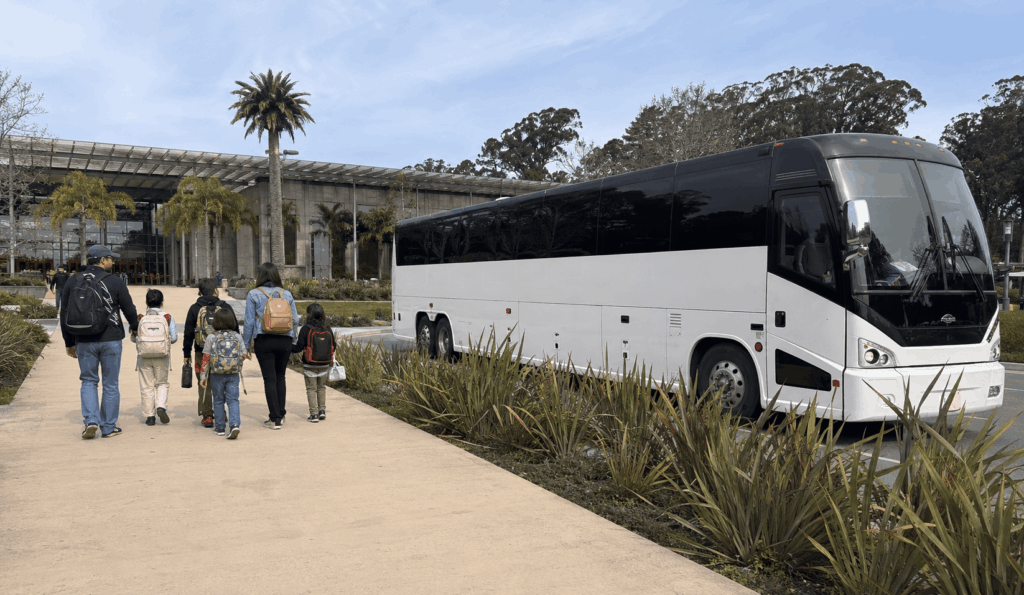 students and chaperones arriving by charter bus for a school field trip at the oakland zoo