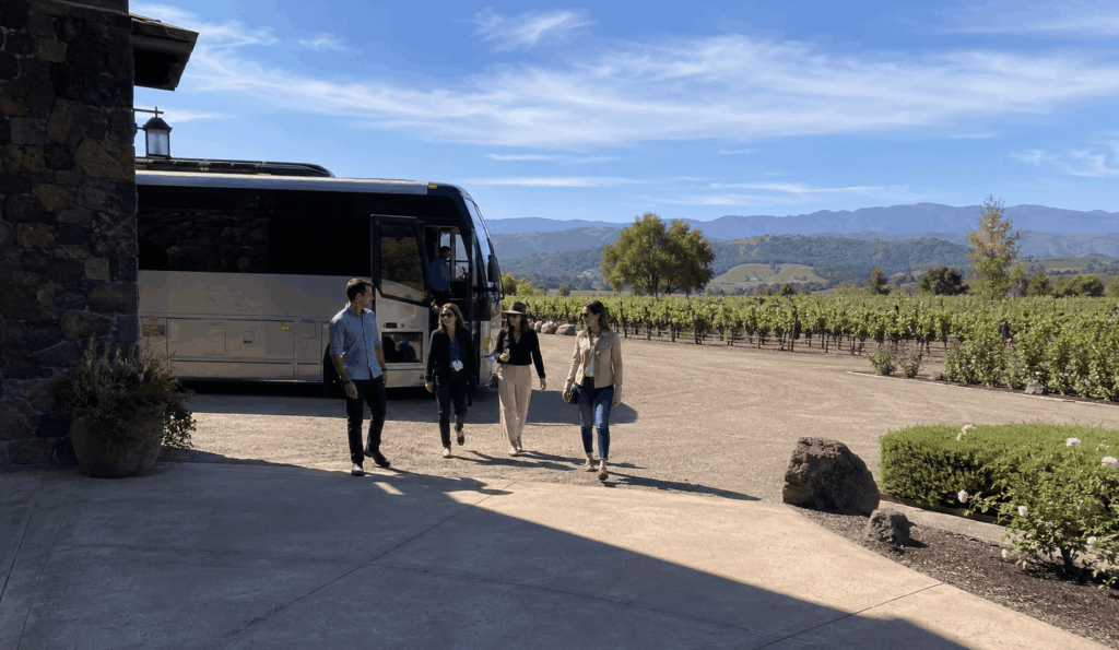 charter bus arriving with a group at a napa valley winery for a wine country day trip from alameda