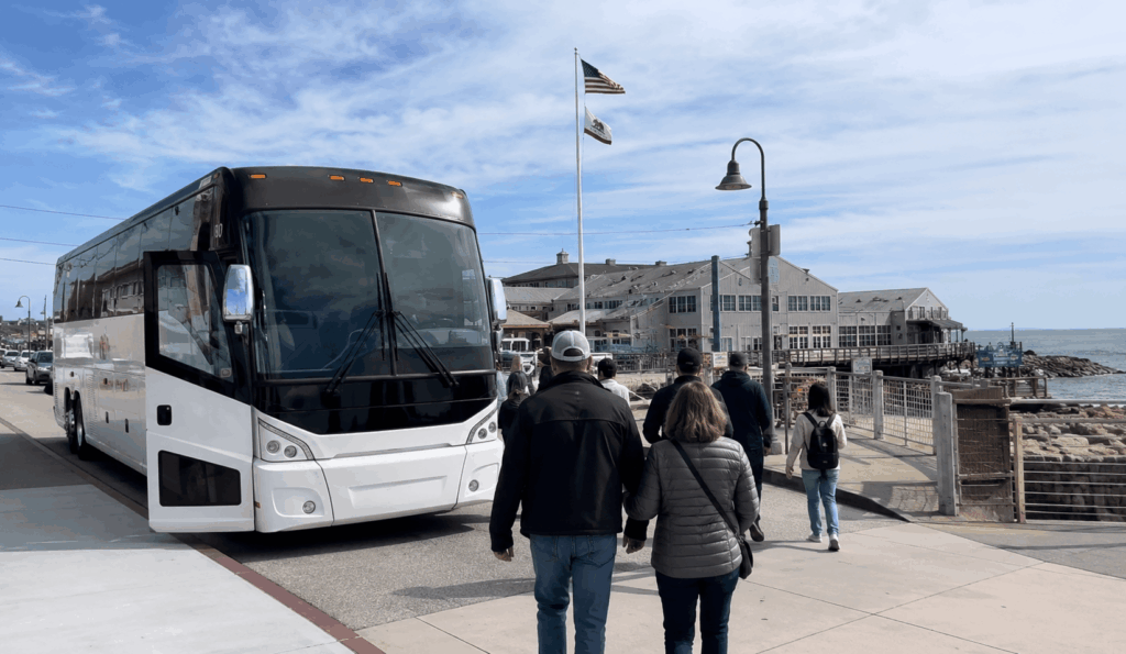 group visiting cannery row in monterey with a charter bus staged nearby during a bay area day trip