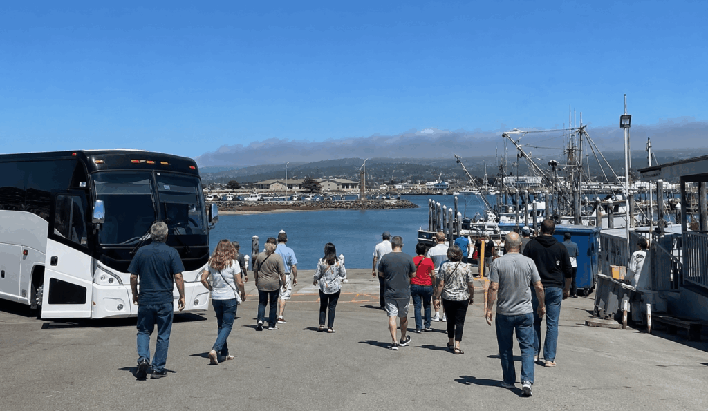 group visiting pillar point harbor near half moon bay after arriving by charter bus