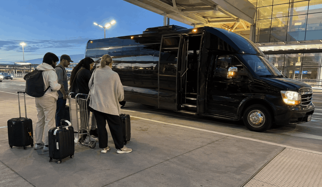 charter bus picking up a group with luggage at the sfo arrivals curb