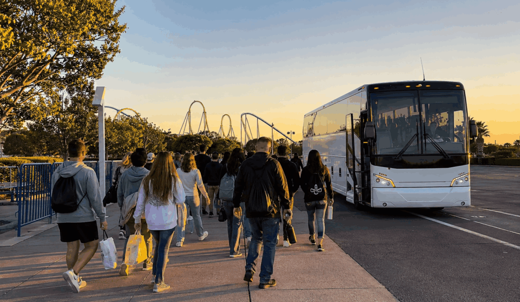 youth group and families walking from a charter bus toward the entrance area of six flags discovery kingdom