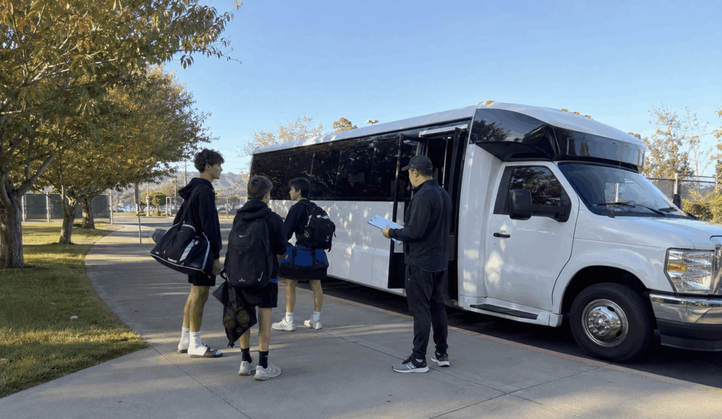 charter bus picking up a youth sports team and coaches outside an alameda school for an away game