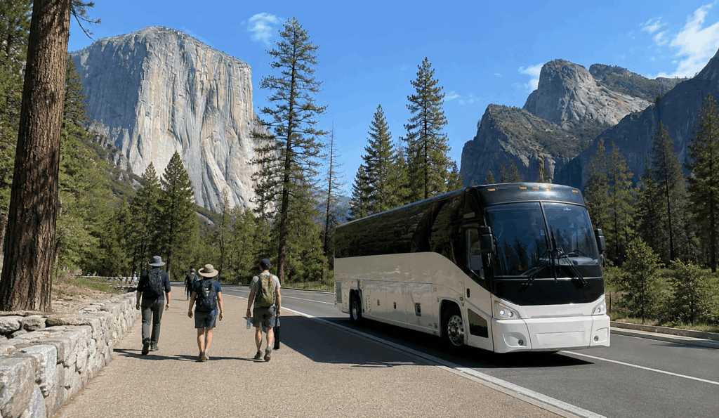 charter bus parked near a yosemite valley stop while a group heads out toward trails and overlooks